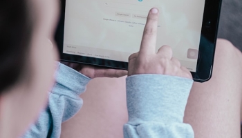 Person searching Google on a tablet